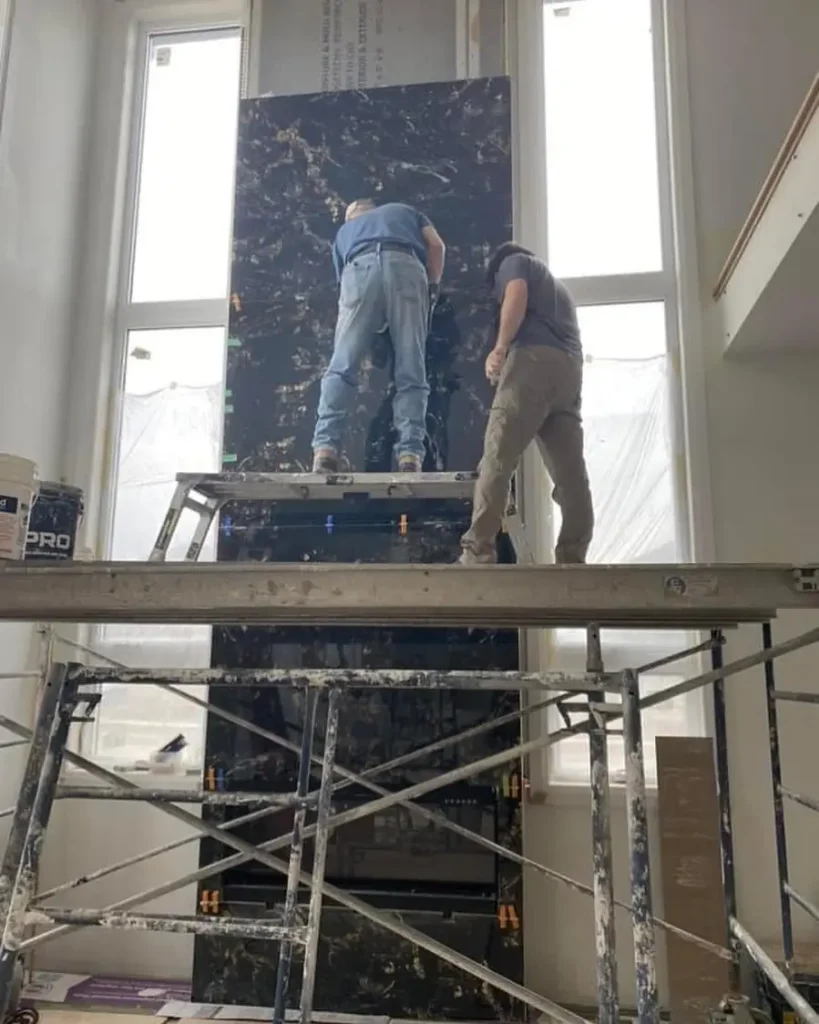 Fireplace installation in the middle of two windows