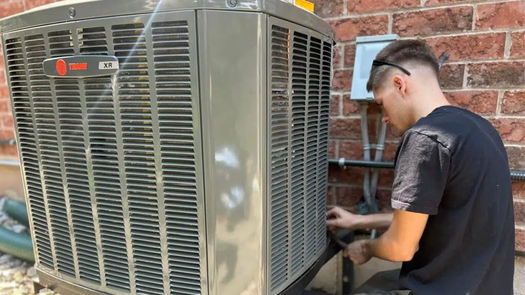 HVAC tech installing a Trane AC