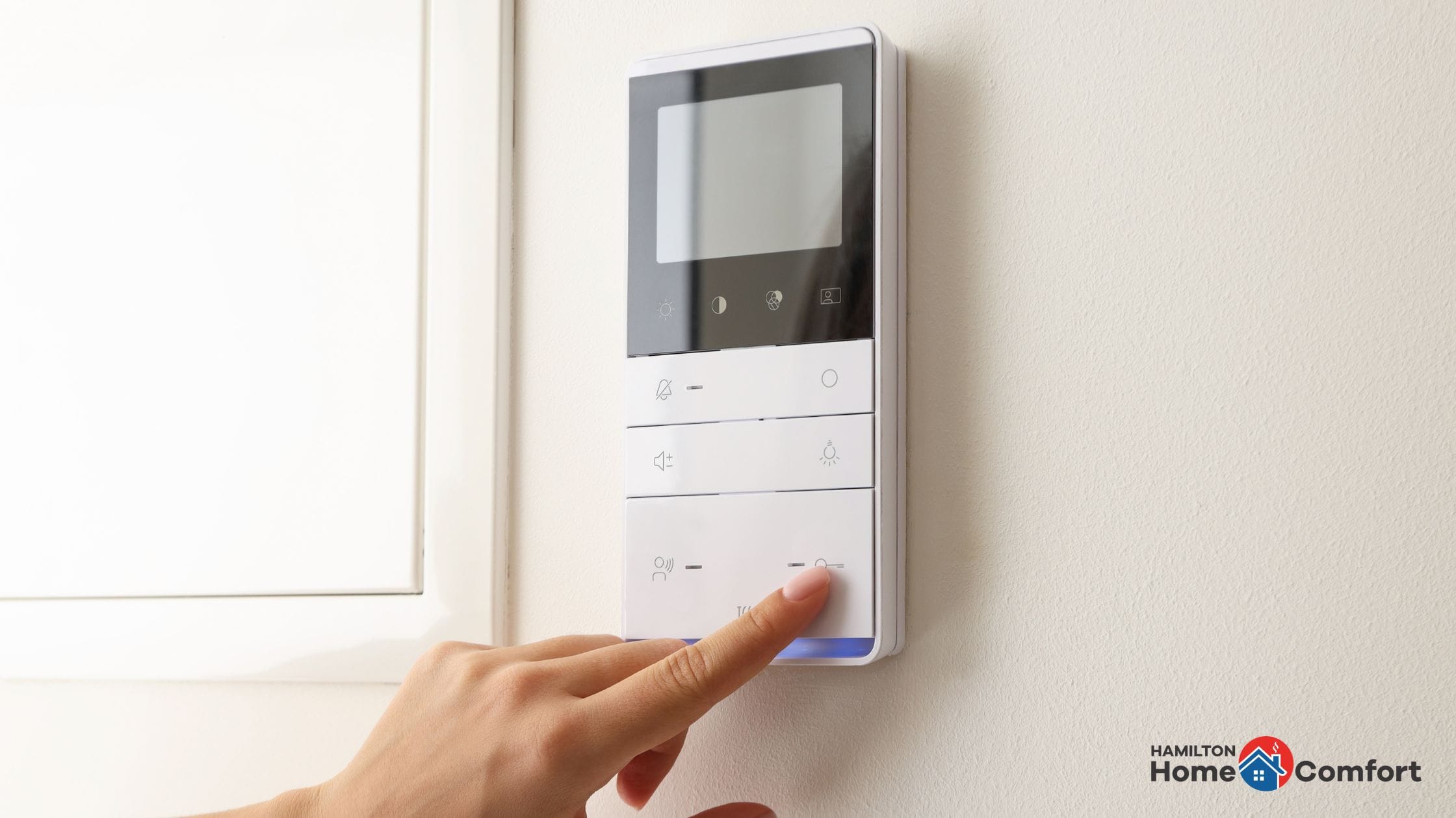 Person using a furnace thermostat - why does my furnace keep turning on and off - Hamilton Home Comfort.