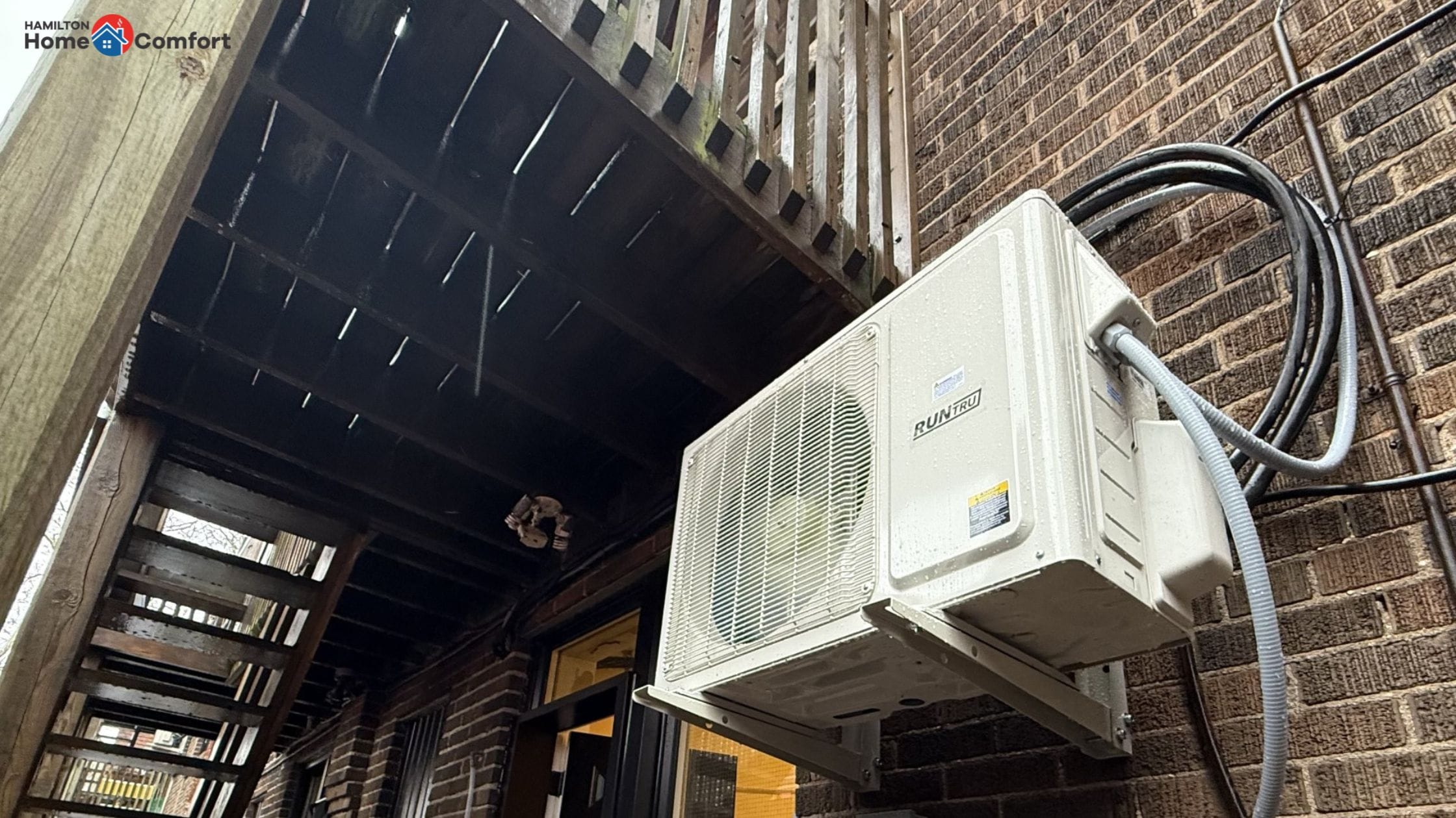 Heat pump on a outdoor home wall - can a heat pump replace a furnace - insights from Hamilton Home Comfort.